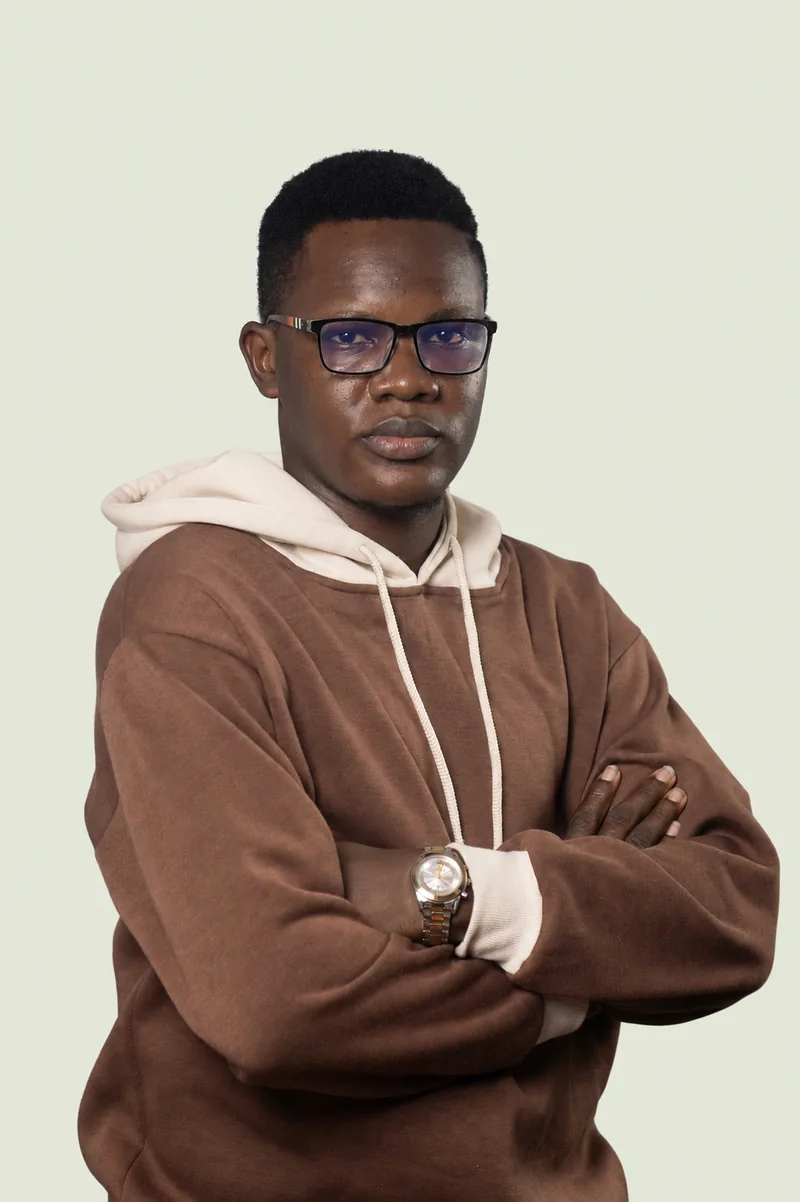 Benaiah, the founder of Tella, in a brown and cream hoodie with his arms folded